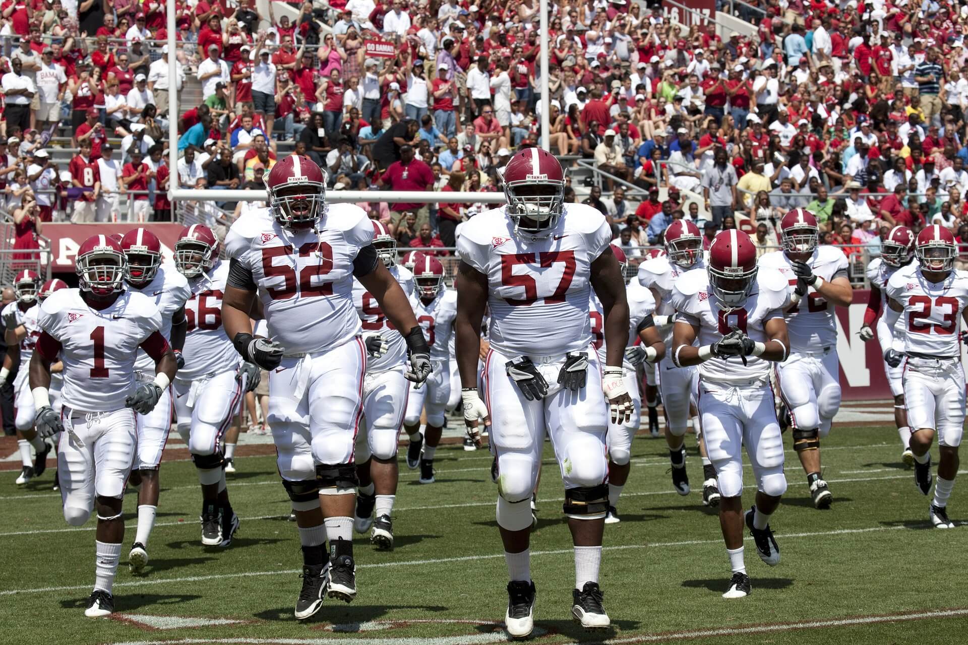 A college football team entering the field of play
