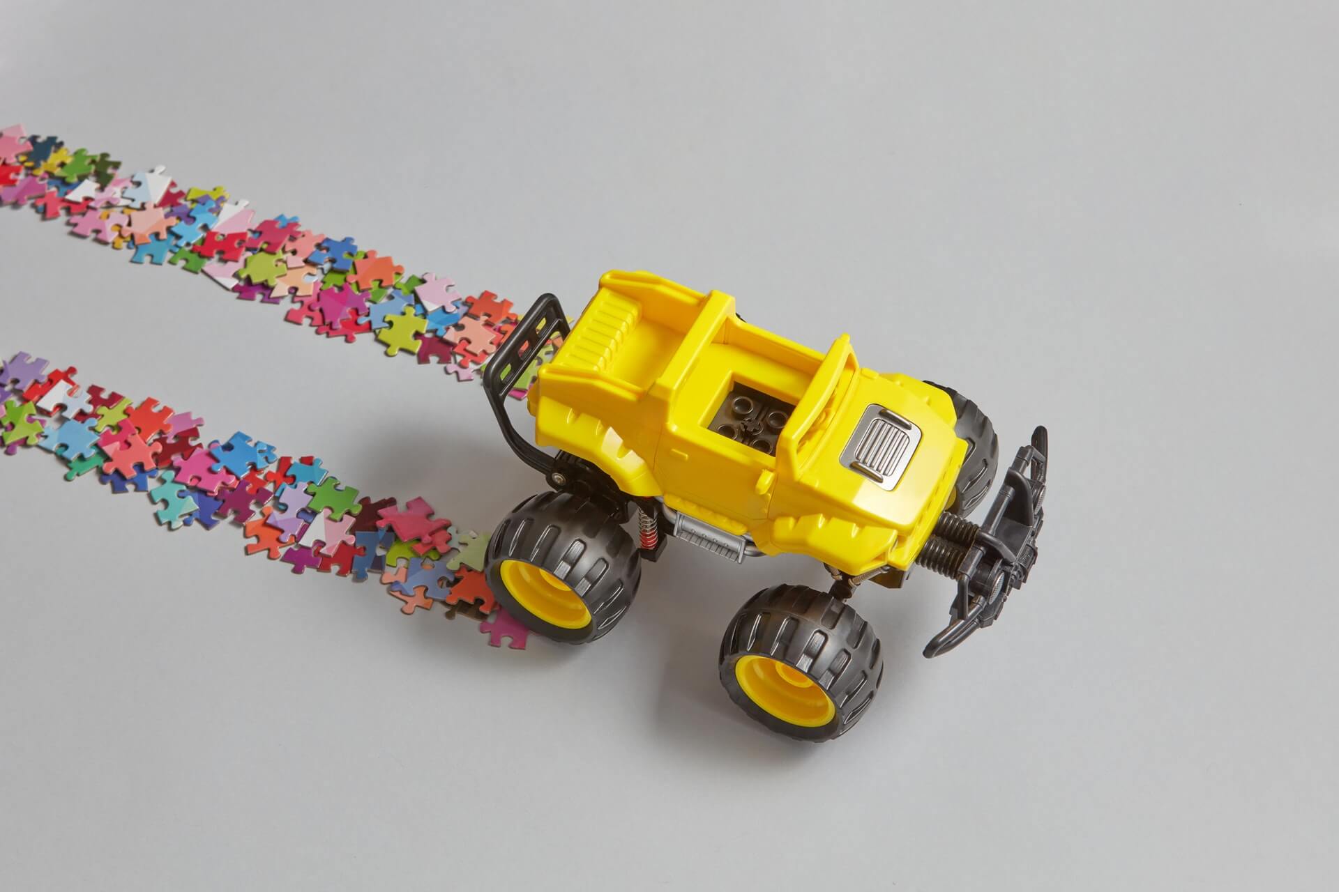 A toy car and puzzles on a white surface