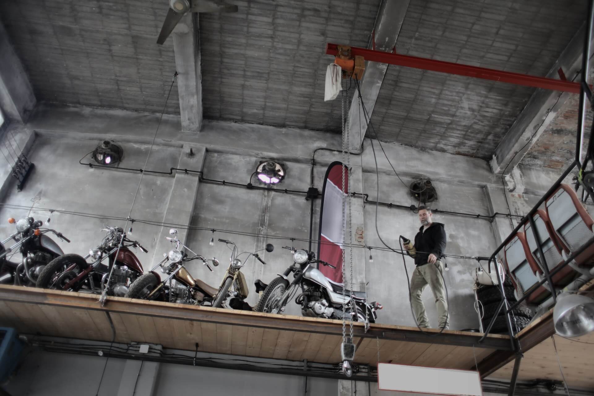 A man standing next to the motorbikes at the vehicle storage
