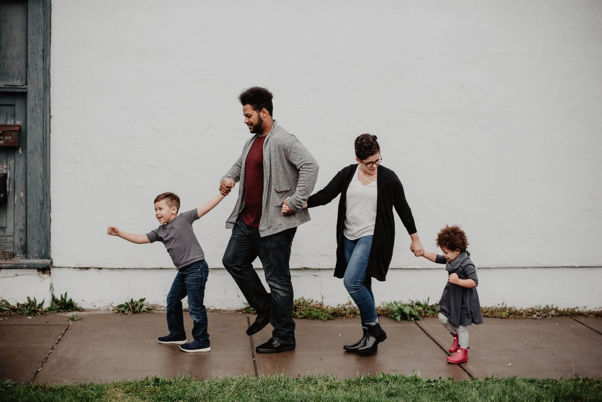 Family of four holding hands and walking